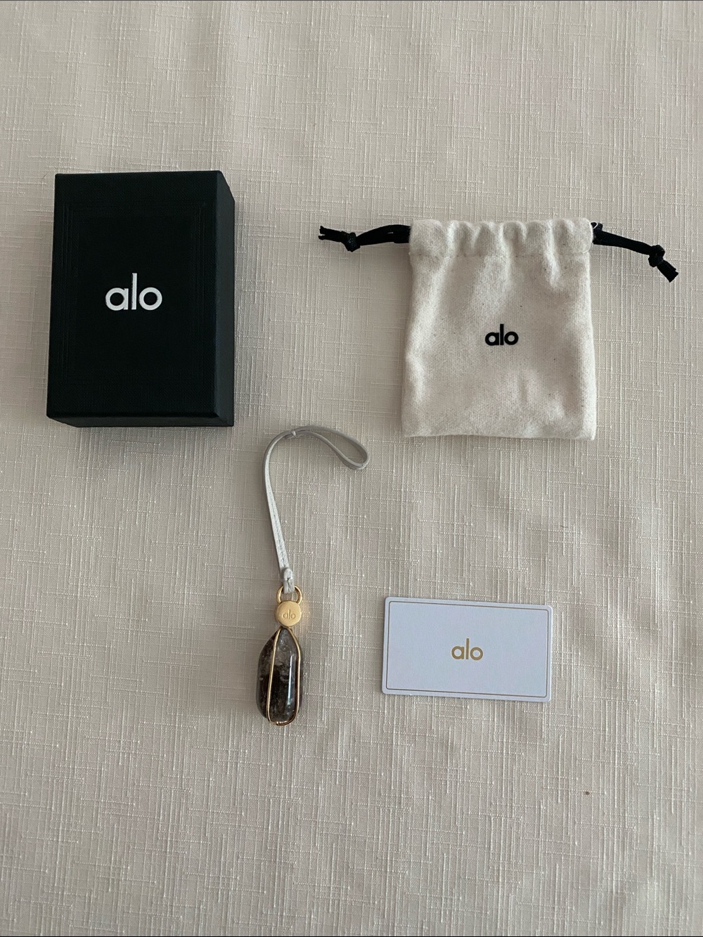Alo Intention Crystal Bag Charm.
(Smoky Quartz/Gold)